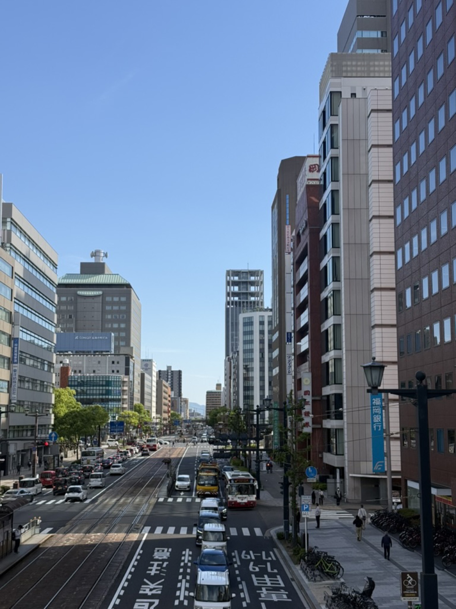Central Hiroshima downtown street with trams, buses and high-rise buildings