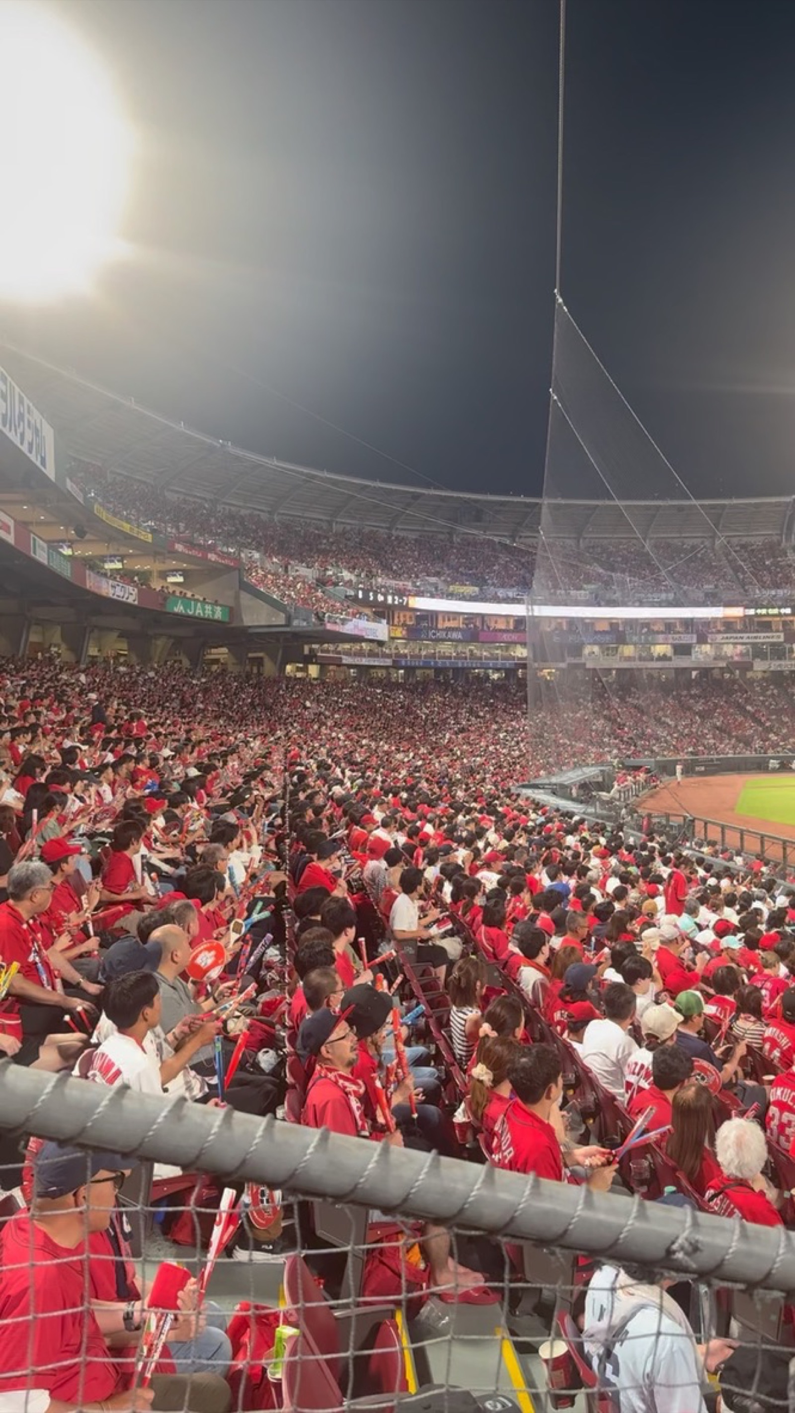 Mazda Stadium packed with Hiroshima Carp fans waving red jet balloons during a home game