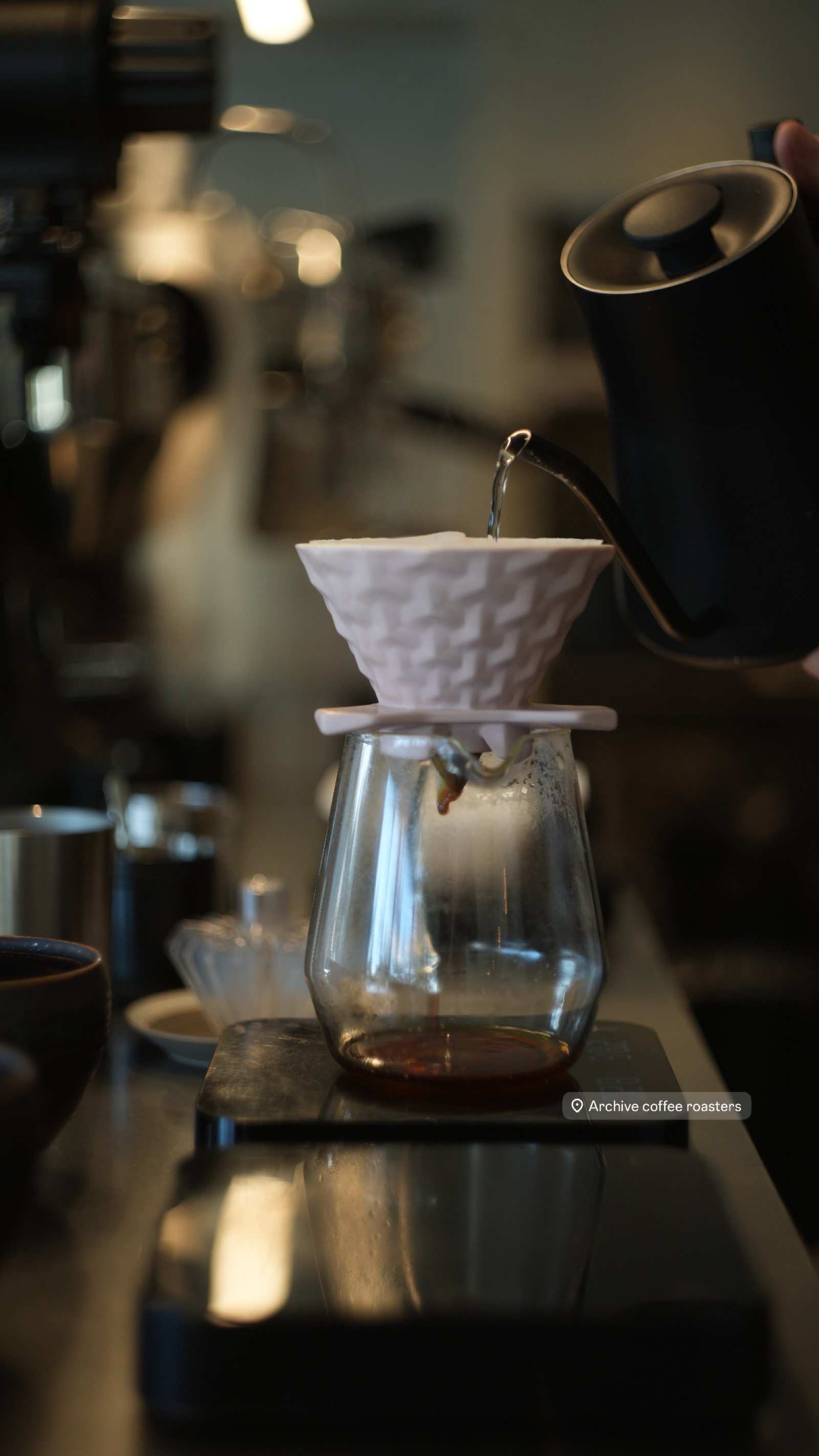 Specialty coffee brewing through white ceramic dripper into glass carafe method