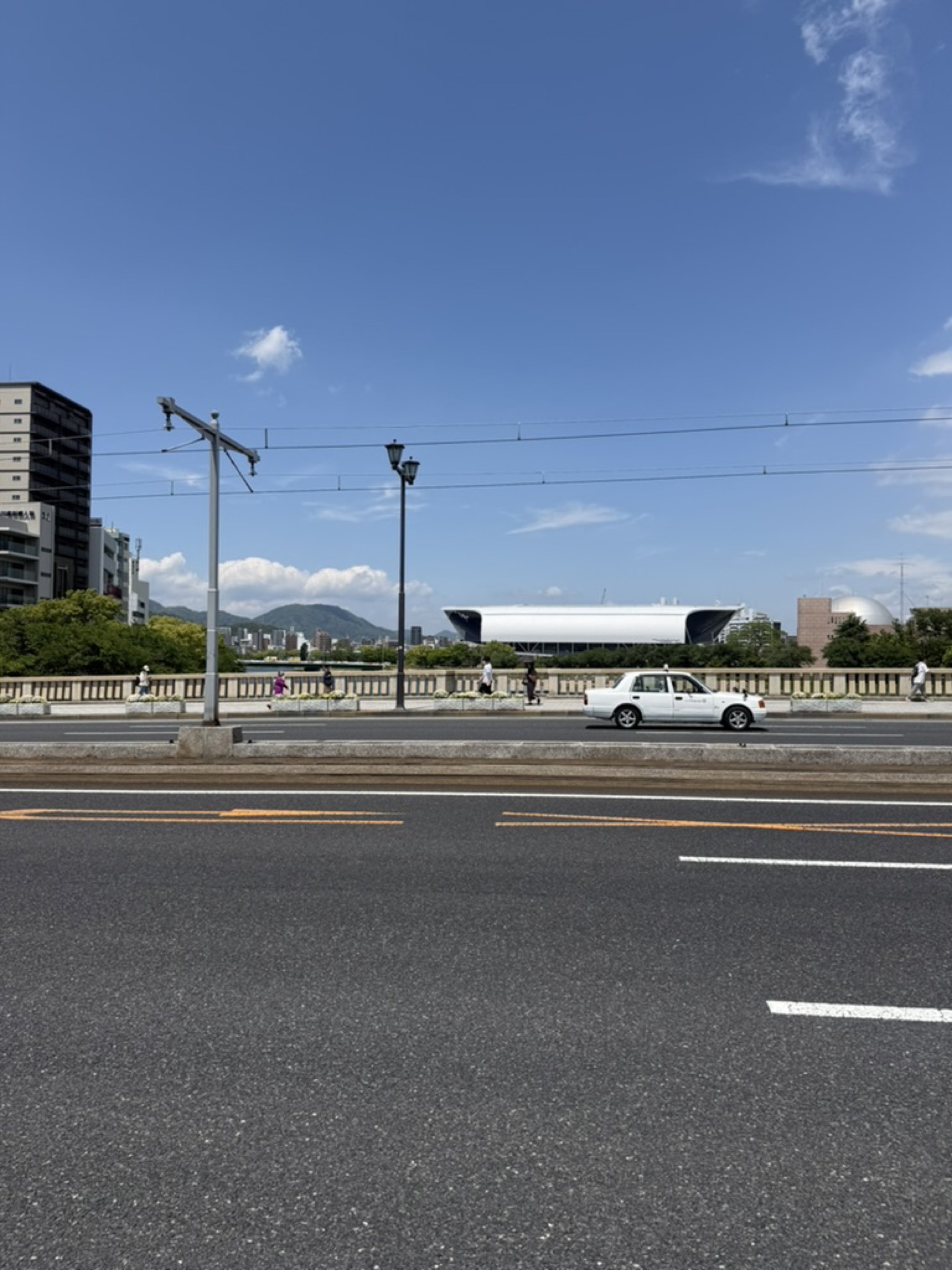 Edion Peace Wing stadium and central Hiroshima skyline under May blue sky