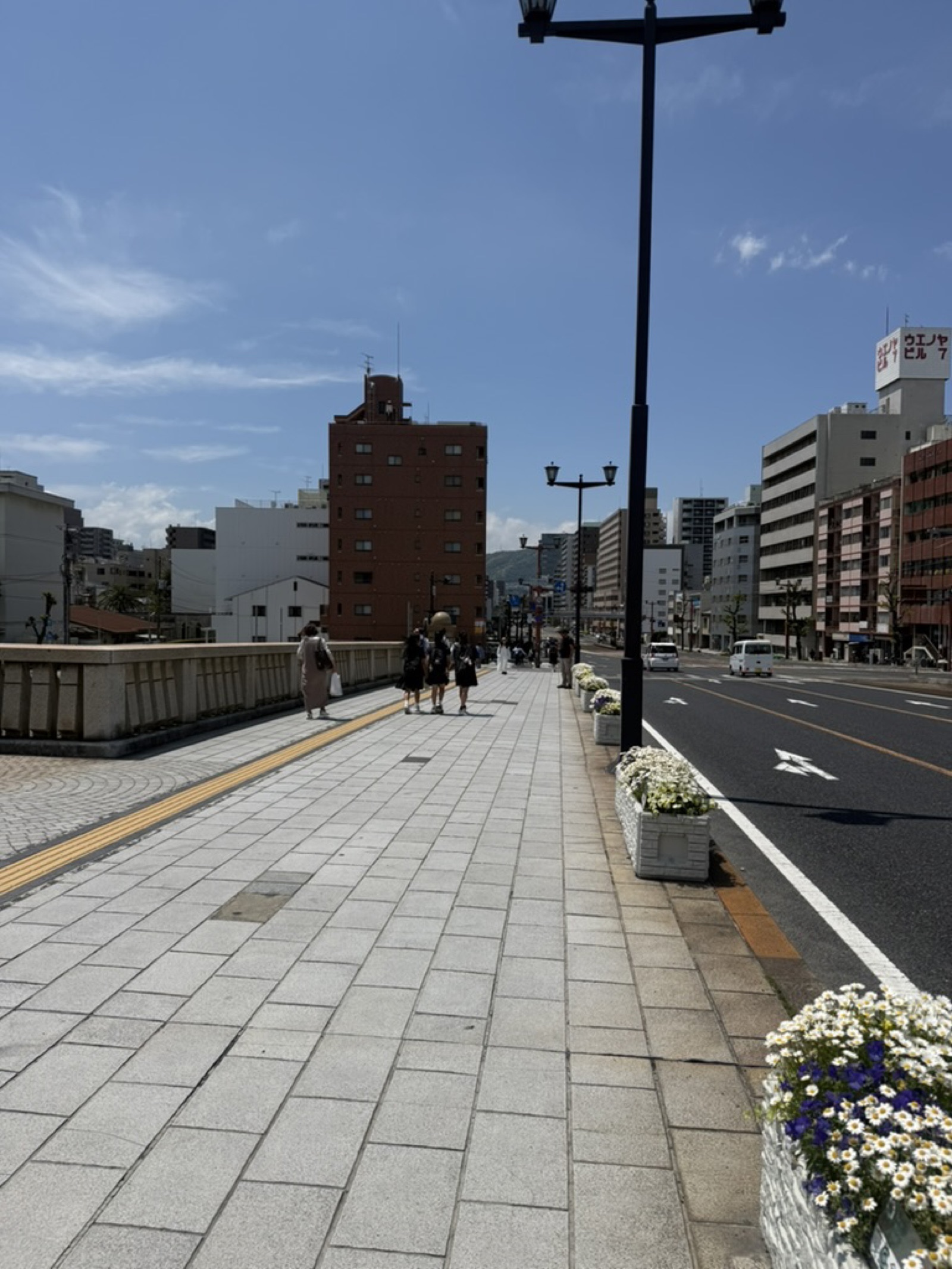 Visitors walking across a bridge in central Hiroshima on a sunny afternoon