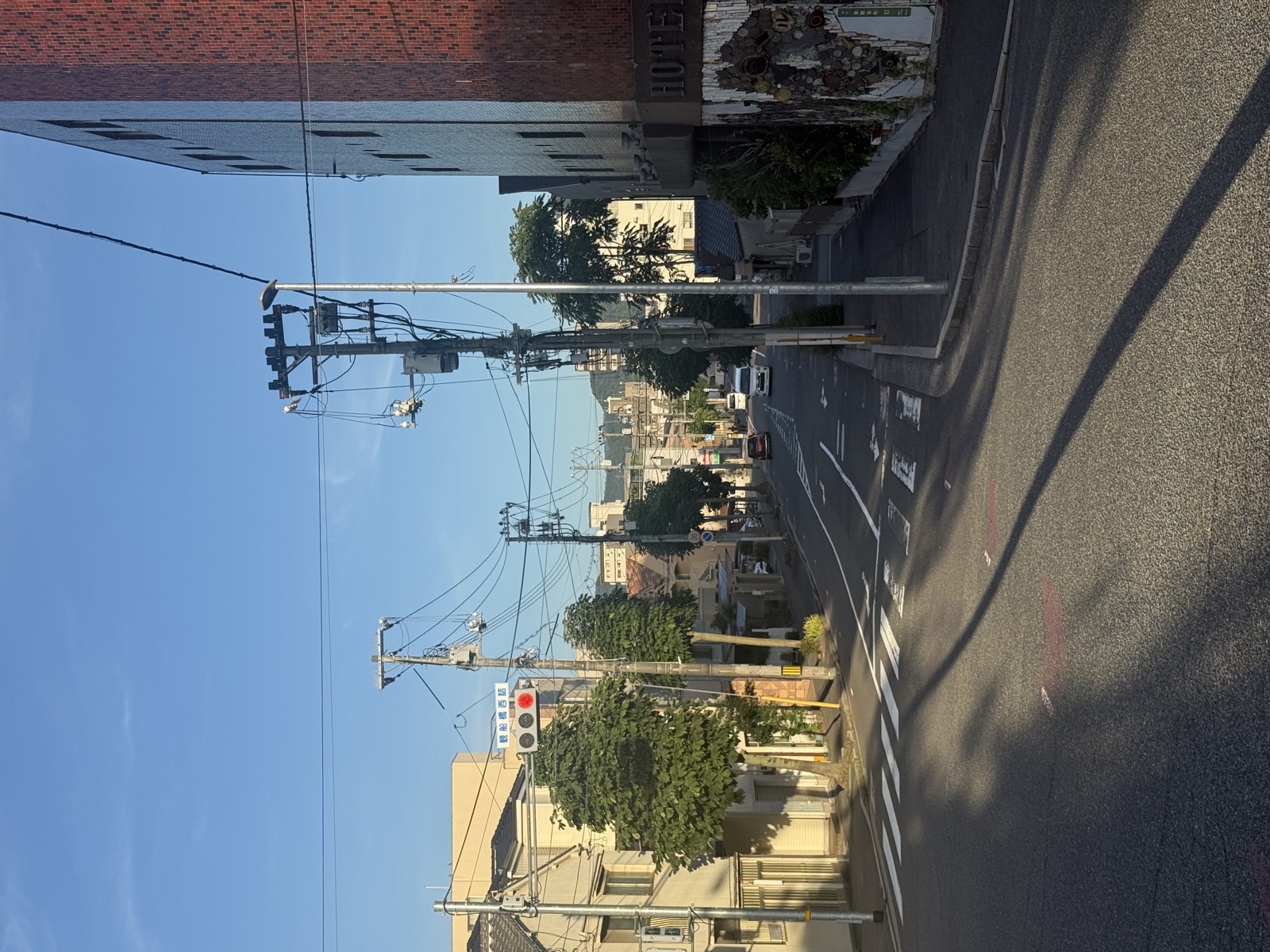 Urban Hiroshima street with clear blue skies and mature trees