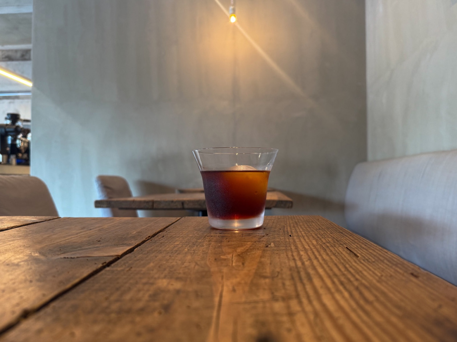 Dim cocktail bar interior with a single glass on the table